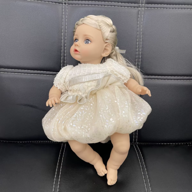 Păpușă Reborn Interactivă Blondă cu Rochie Albă și Voce – 35 cm