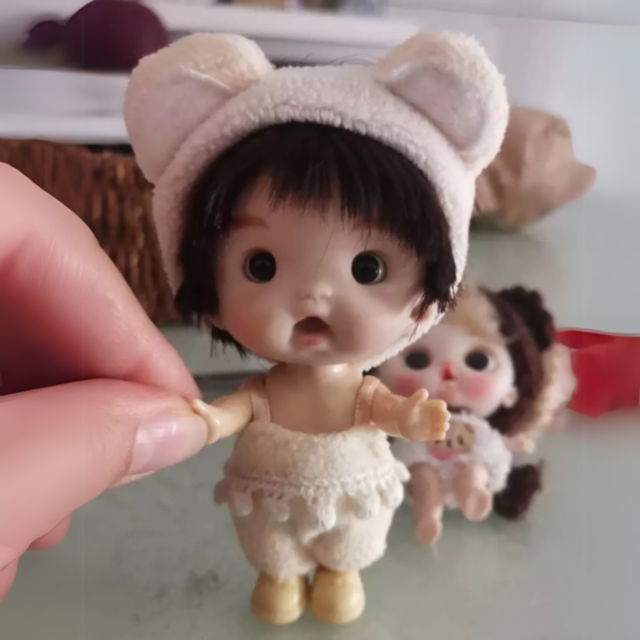 Păpușă Bebe Fetiță cu Căciuliță Urechi și Hăinuțe Pufoase | Jucărie de Colecție și Cadou Adorabil